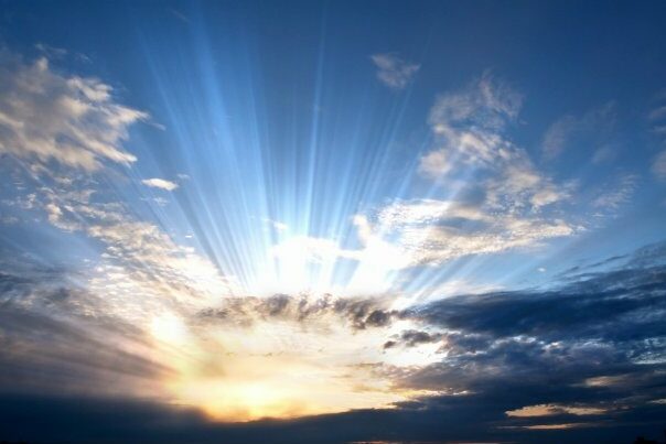Dark clouds with sun rays over sea.
